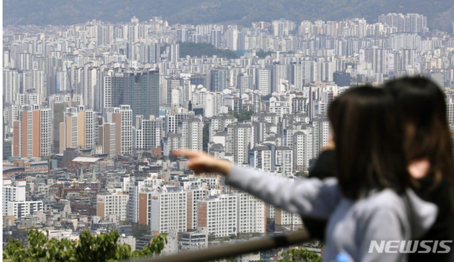 여자 두명이 손을 가리키며 아파트가 즐비한 도심을 보는 모습 이미지 